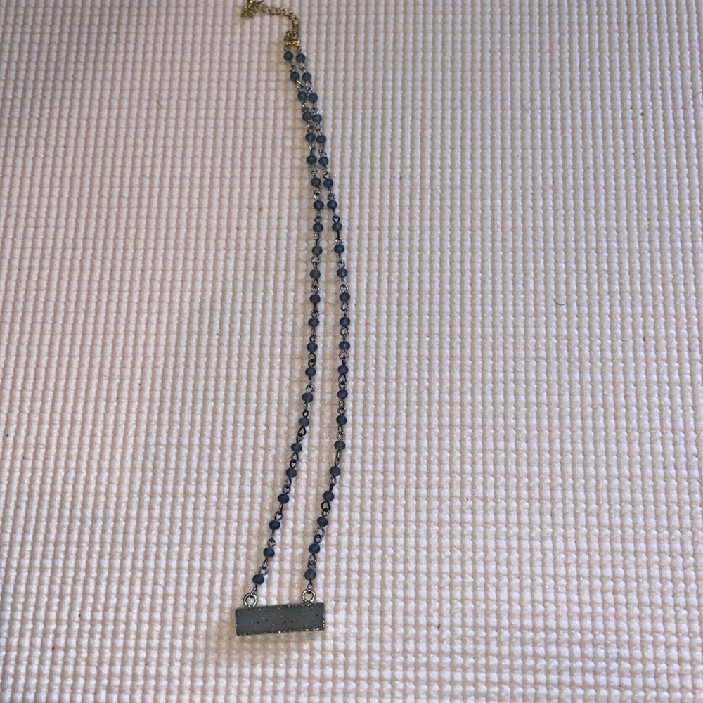 Gray beaded necklace with shiny stone. Gold chain.